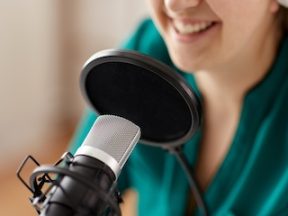 woman with microphone recording podcast at studio